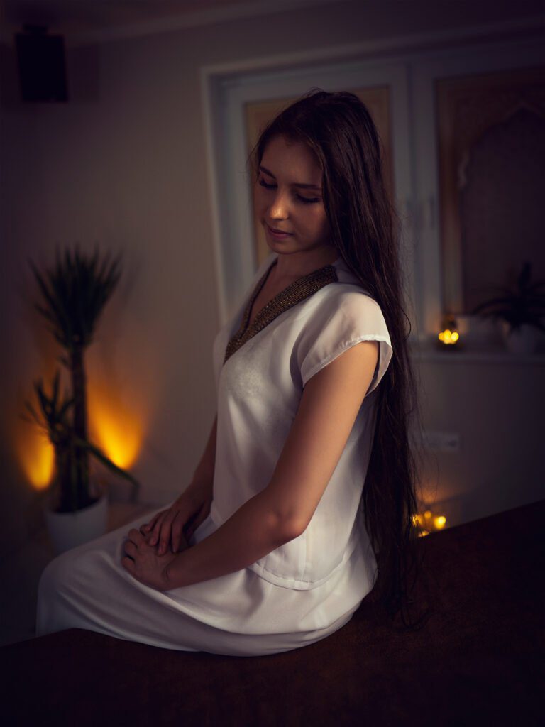 Julia Konik siedząca na stole do masażu w Masaże Świata SPA w Wirach